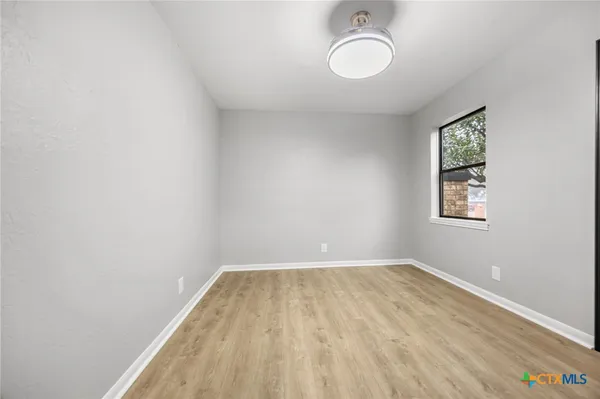 a view of a room with wooden floor and window