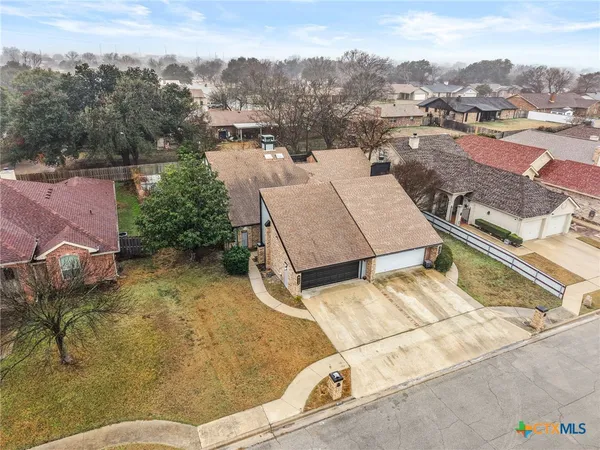 an aerial view of a house with a yard and mountain view in back