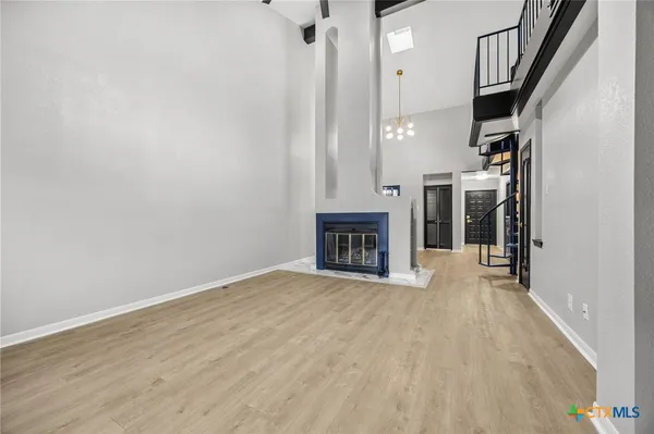 an empty room with wooden floor and fireplace