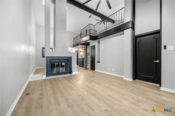 a view of empty room with wooden floor and fireplace