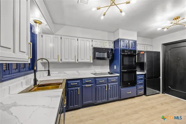 a kitchen with stainless steel appliances granite countertop a sink and cabinets