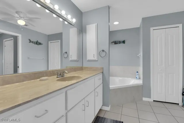 a bathroom with a granite countertop sink a mirror and a bathtub