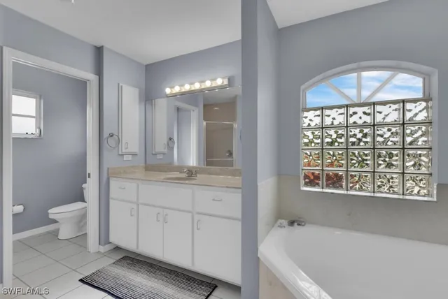 a bathroom with a granite countertop sink a toilet and bathtub