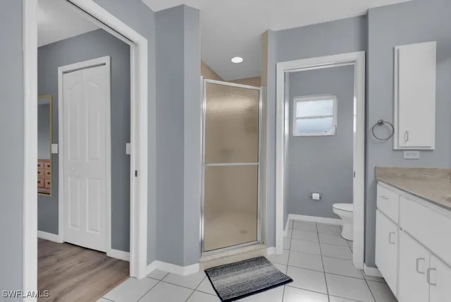 a bathroom with a granite countertop toilet and a shower