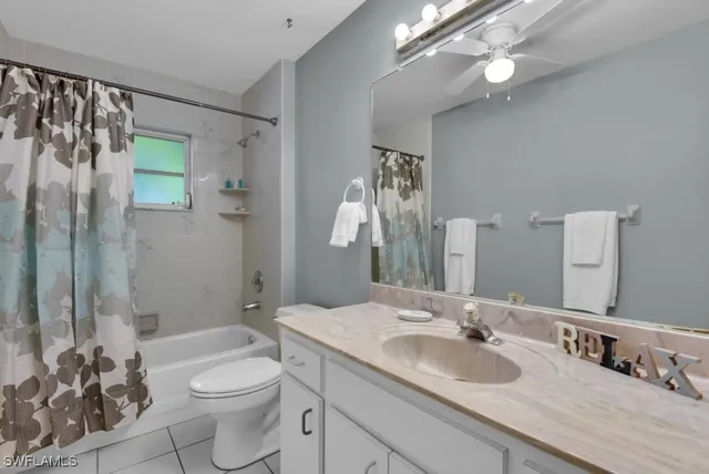a bathroom with a granite countertop sink toilet a mirror a vanity and shower