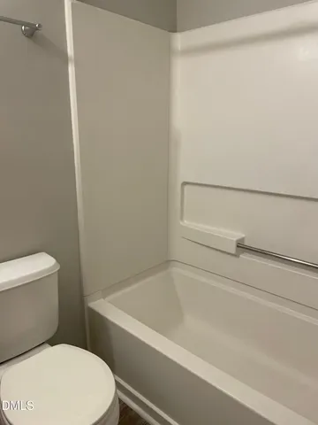 a white toilet sitting next to a bath tub