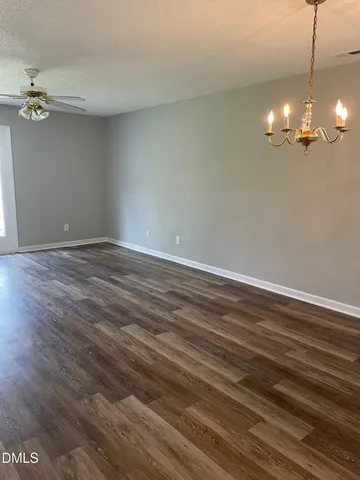a view of a room with a flat screen tv and a ceiling fan