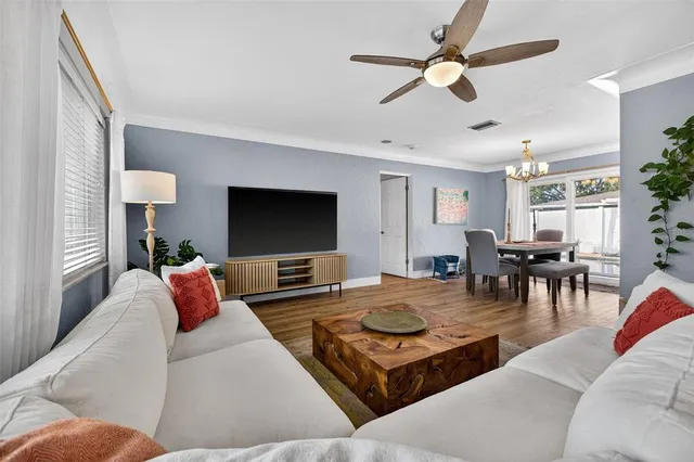 a living room with furniture kitchen view and a large window