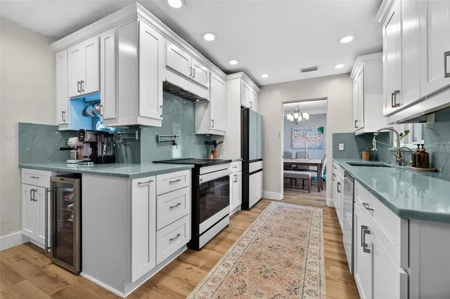 a kitchen with stainless steel appliances granite countertop a stove a sink and a refrigerator