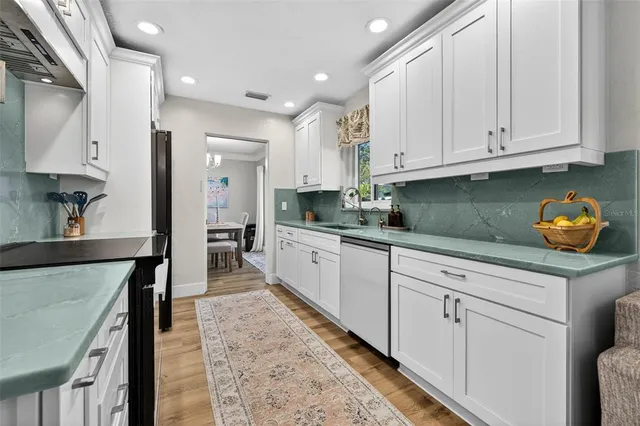a kitchen with granite countertop white cabinets and stainless steel appliances