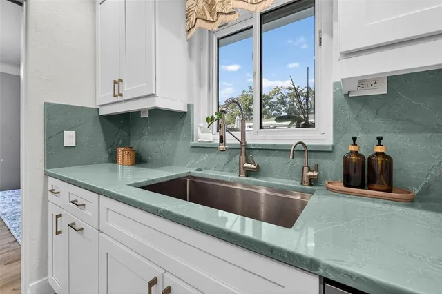 a kitchen with granite countertop a sink and cabinets