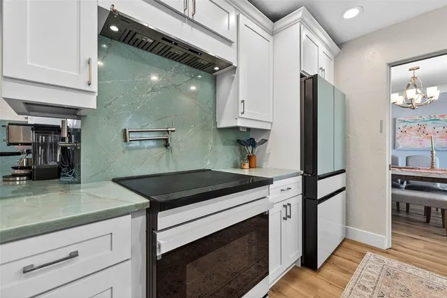 a kitchen with stainless steel appliances granite countertop a stove a refrigerator and a sink
