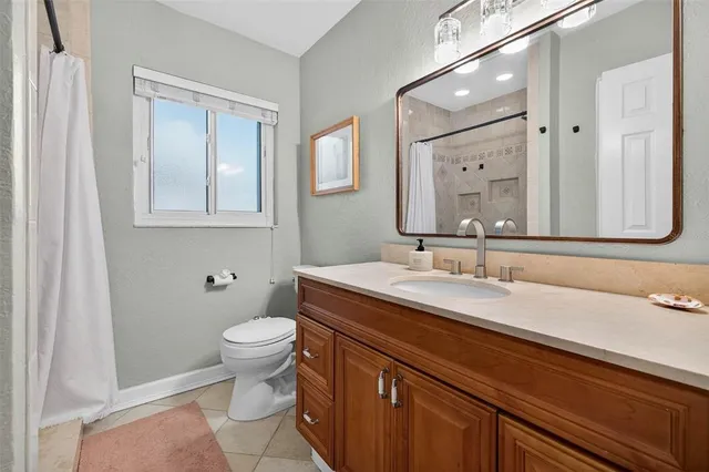 a bathroom with a granite countertop sink a toilet and a mirror