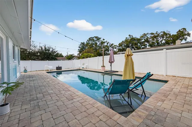 swimming pool view with a seating space