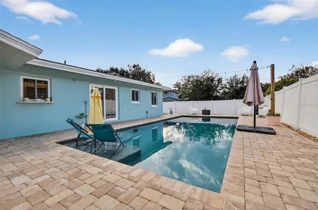 a swimming pool with outdoor seating and yard