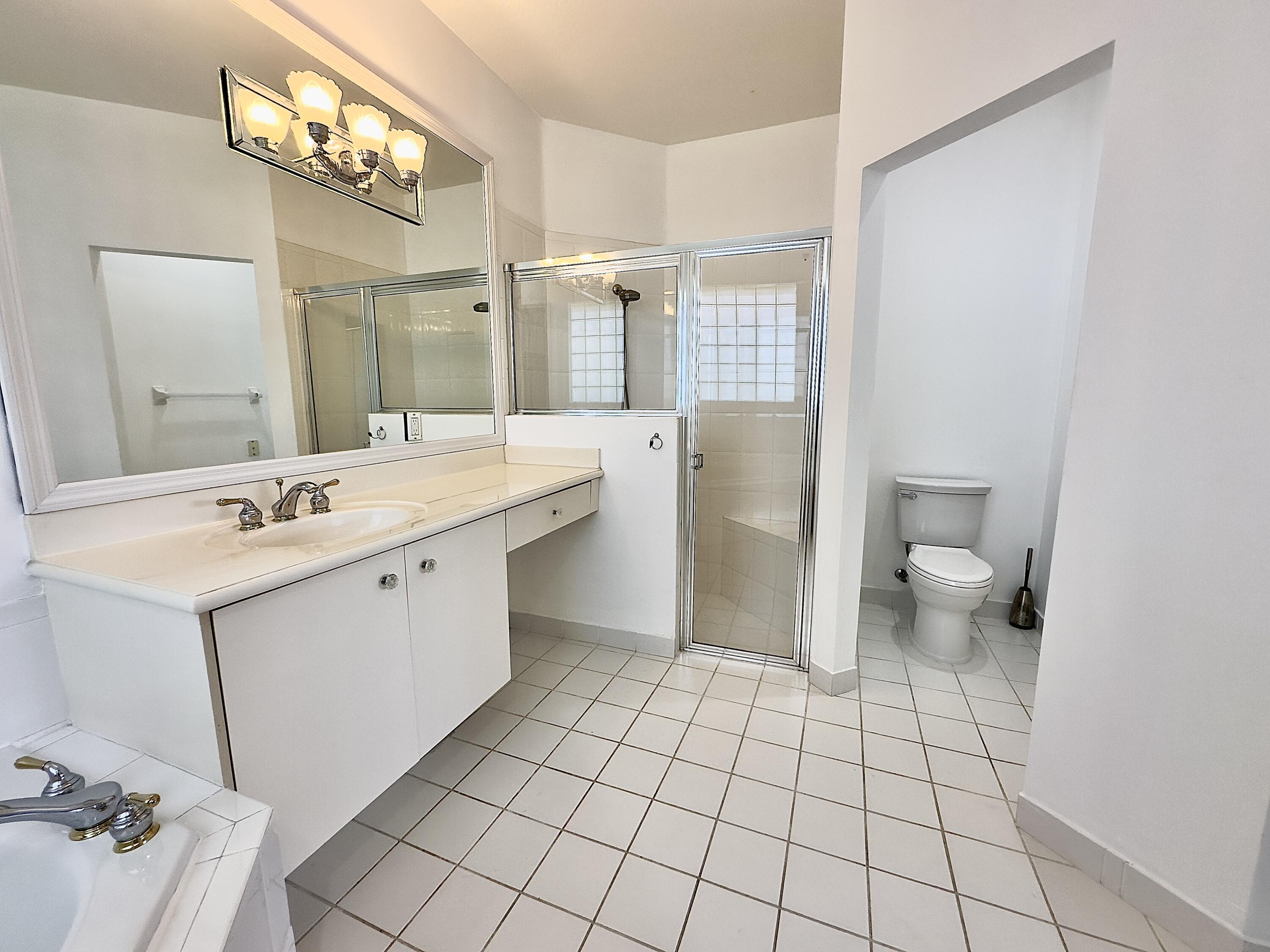7096 Cataluna Circle Delray Beach, FL 33446 - Photo 11 of 32 a spacious bathroom with a double vanity sink toilet and a mirror