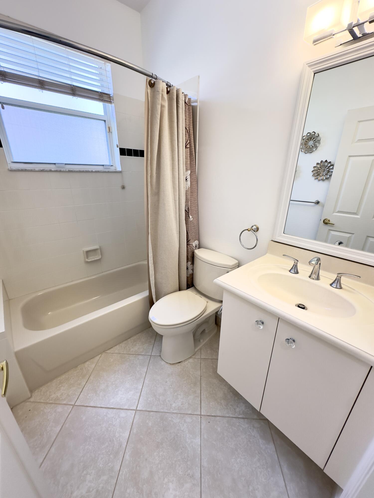7096 Cataluna Circle Delray Beach, FL 33446 - Photo 13 of 32 a bathroom with a double vanity sink toilet and shower