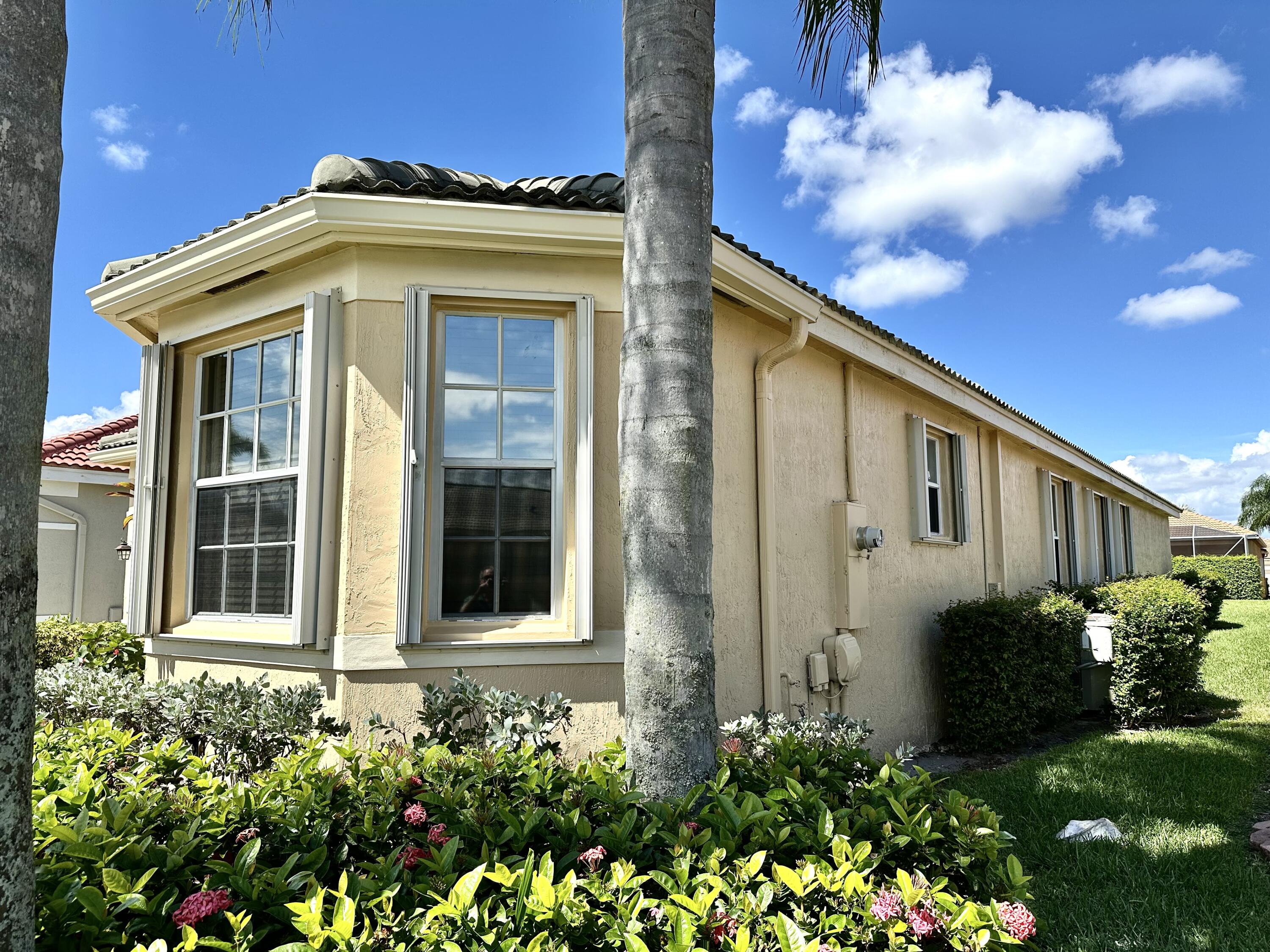 7096 Cataluna Circle Delray Beach, FL 33446 - Photo 20 of 32 a front view of a house with a yard
