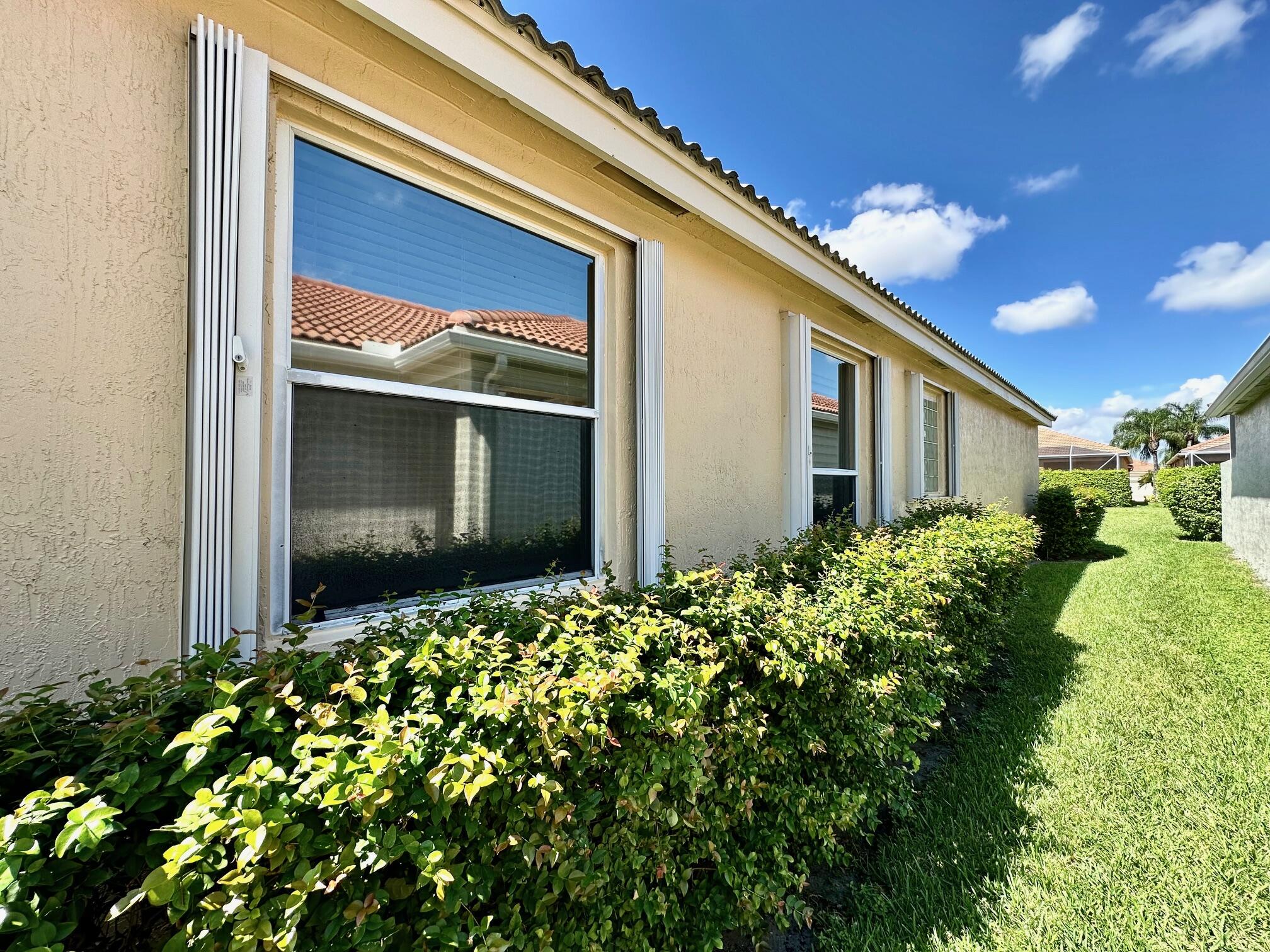 7096 Cataluna Circle Delray Beach, FL 33446 - Photo 21 of 32 a front view of a house with plants
