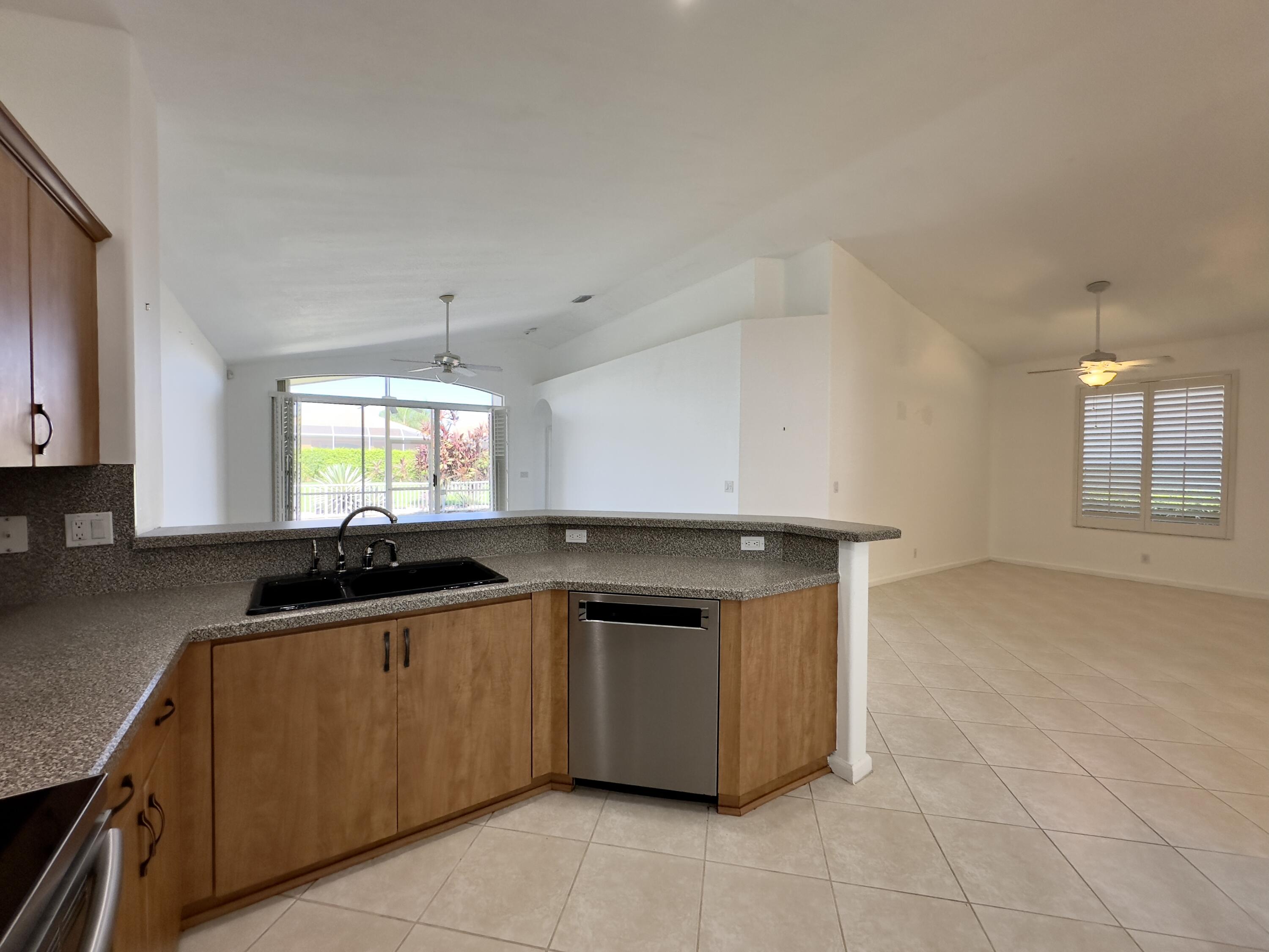 7096 Cataluna Circle Delray Beach, FL 33446 - Photo 30 of 32 a kitchen with stainless steel appliances granite countertop a sink and cabinets