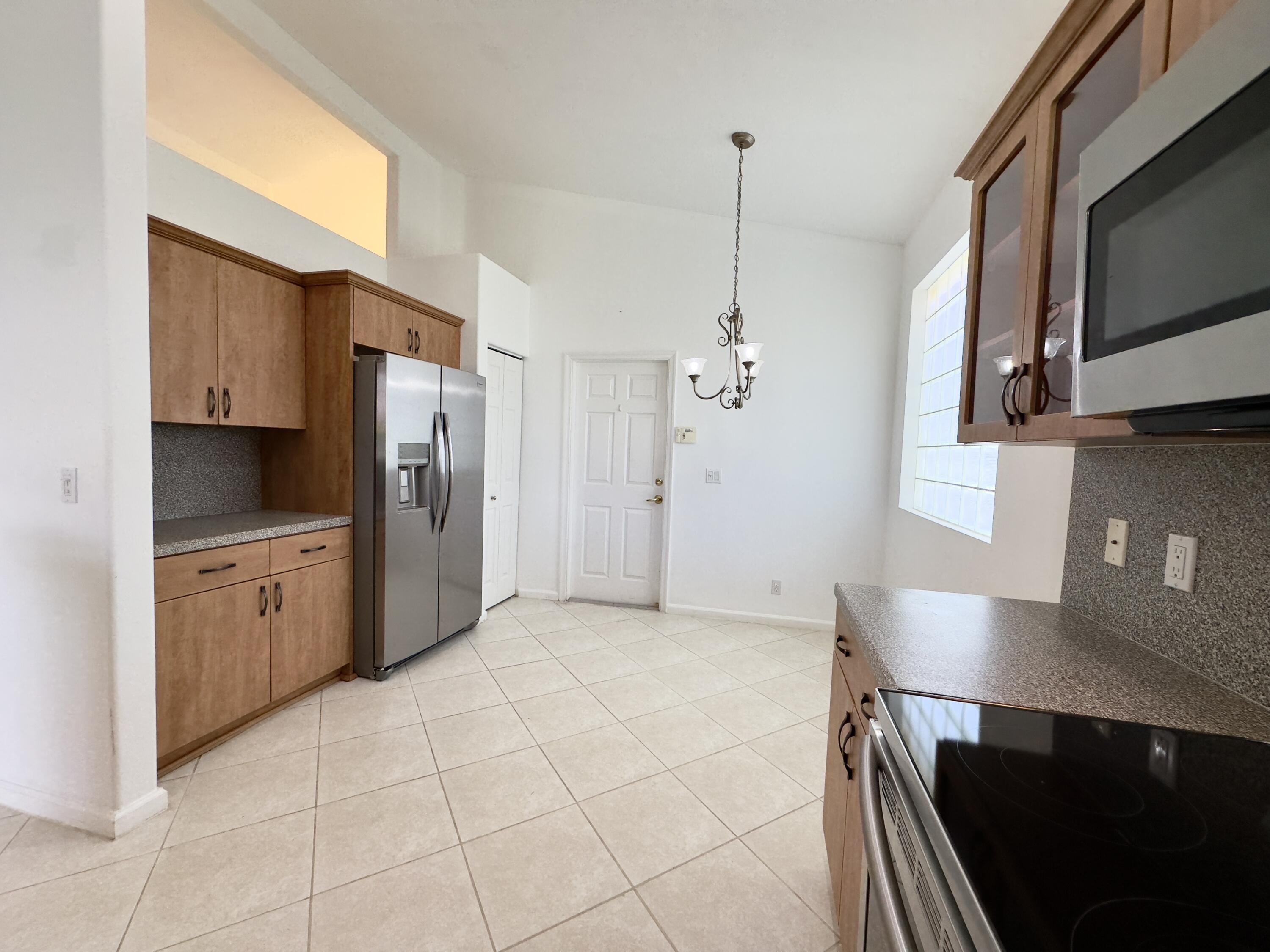 7096 Cataluna Circle Delray Beach, FL 33446 - Photo 5 of 32 a kitchen with stainless steel appliances a refrigerator sink and microwave