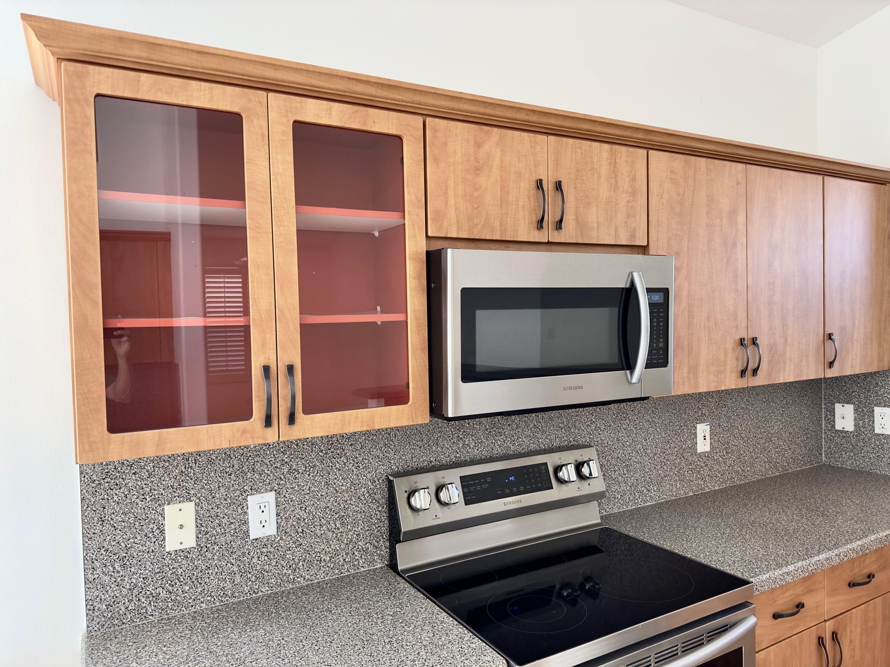 7096 Cataluna Circle Delray Beach, FL 33446 - Photo 6 of 32 a kitchen with granite countertop white cabinets and stainless steel appliances