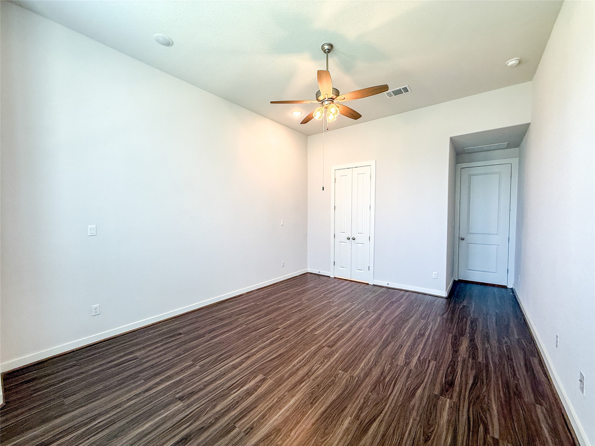 249 Heartleaf Road San Marcos, TX 78666 - Photo 21 of 38 Laminate flooring and a ceiling fan create a comfortable and adaptable personal space.