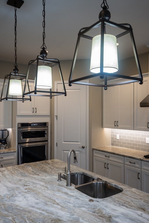 20 Sequoia Drive, Unit 20 Methuen, MA 01844 - Photo 7 of 42 a kitchen with kitchen island a stove a sink and wooden floor