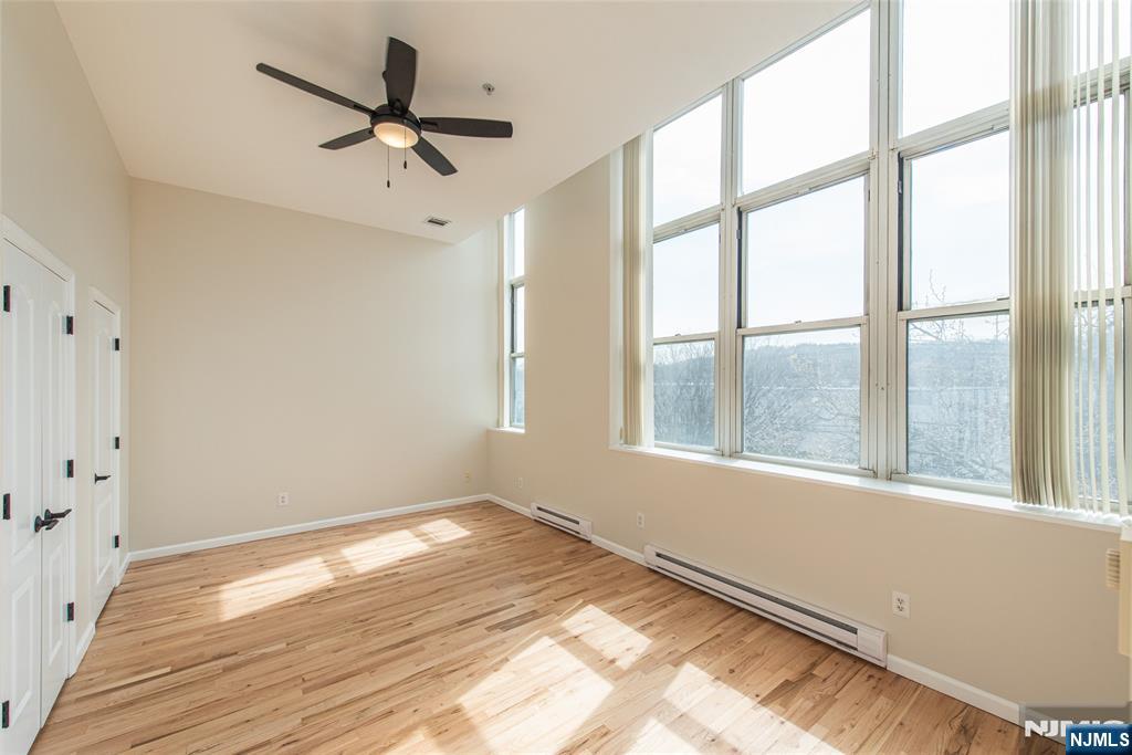280 Main Street, Unit 305 Little Falls, NJ 07424 - Photo 13 of 24 wooden floor in an empty room with a window