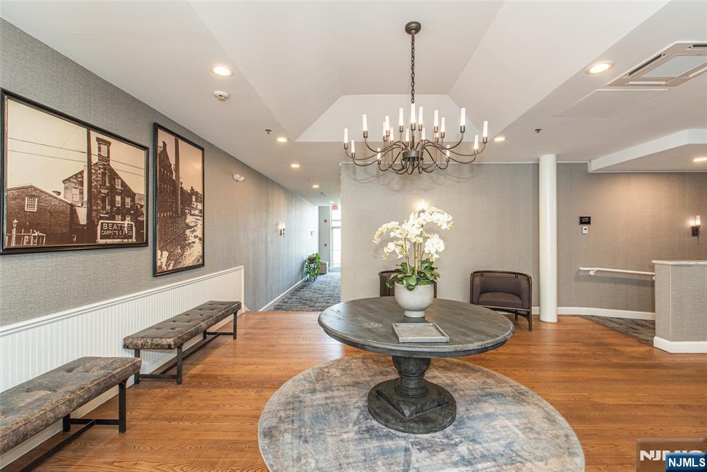280 Main Street, Unit 305 Little Falls, NJ 07424 - Photo 18 of 24 a dining room with furniture a chandelier and wooden floor