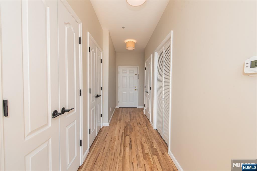 280 Main Street, Unit 305 Little Falls, NJ 07424 - Photo 2 of 24 a view of a hallway with wooden floor and closet area