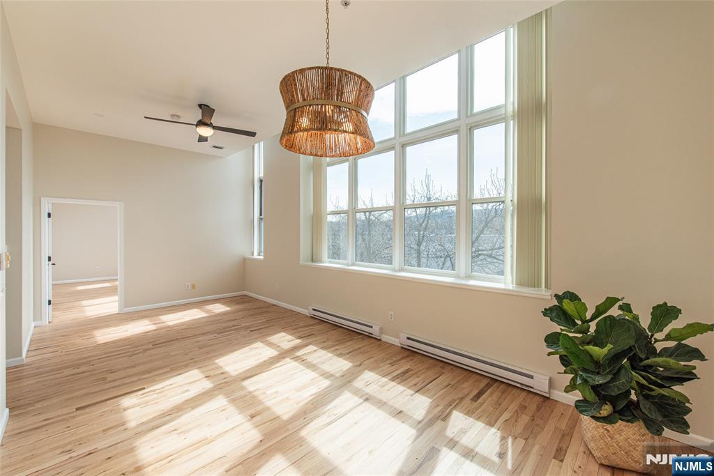 280 Main Street, Unit 305 Little Falls, NJ 07424 - Photo 6 of 24 a view of empty room with wooden floor and floor to ceiling window