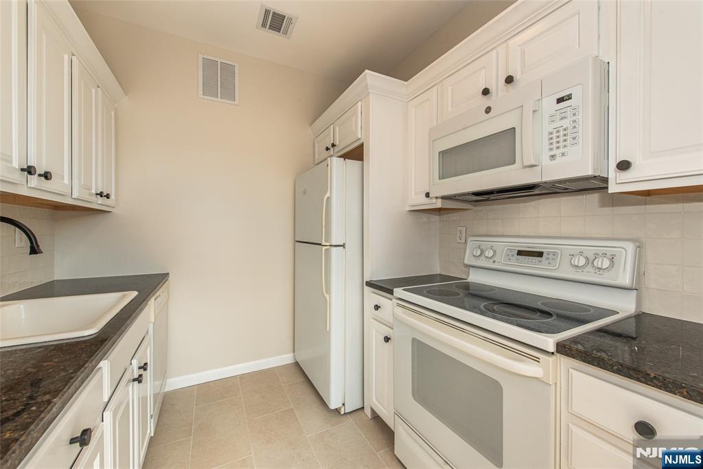 280 Main Street, Unit 305 Little Falls, NJ 07424 - Photo 10 of 24 a kitchen with granite countertop cabinets stainless steel appliances and sink