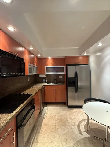 a large kitchen with stainless steel appliances and large counter top