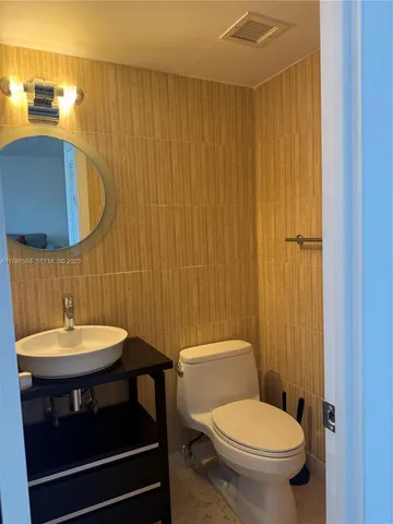 a bathroom with a sink a toilet and mirror