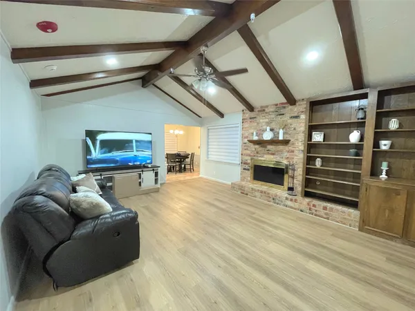 a living room with fireplace furniture and a wooden floor