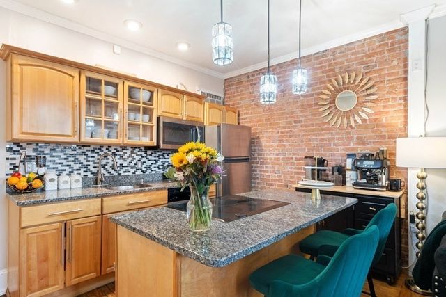 a kitchen with stainless steel appliances granite countertop a sink a counter space and cabinets
