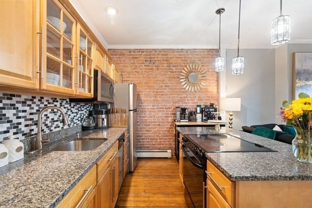 a kitchen with stainless steel appliances granite countertop sink stove and cabinets