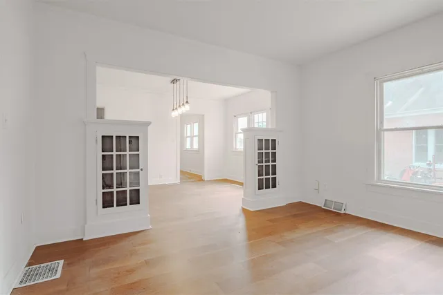 an empty room with windows and cabinet