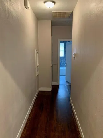 a view of a hallway with wooden floor