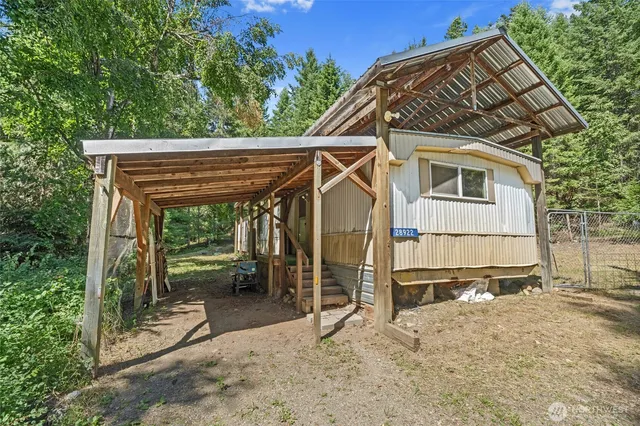 a view of a house with a wooden fence next to a yard