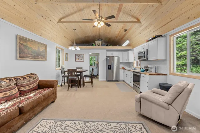a living room with furniture kitchen view and a large window