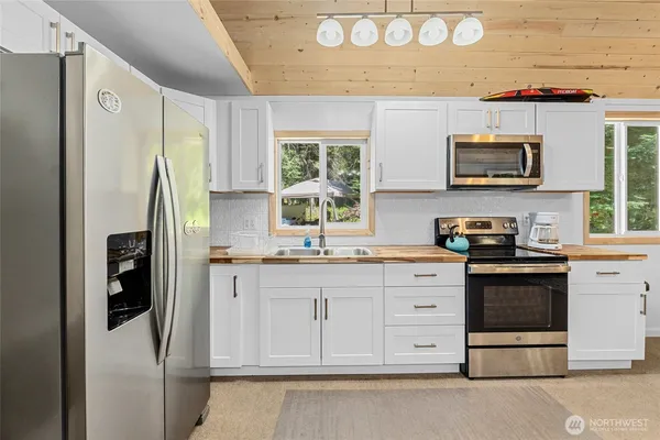 a kitchen with stainless steel appliances granite countertop a stove a sink and a refrigerator