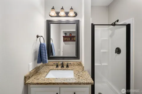 a bathroom with a granite countertop sink and a mirror