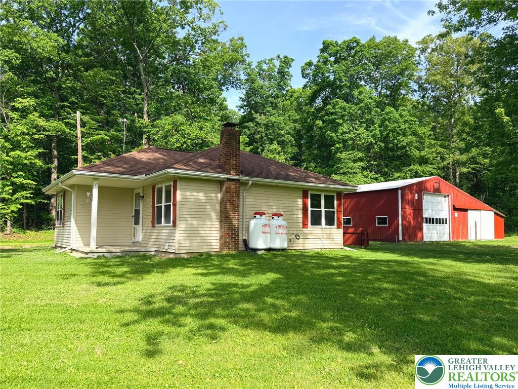 4995 Mountain Road Slatington, PA 18080 - Photo 22 of 30 A charming single-story residence with a classic red barn, nestled within a verdant, treed landscape.