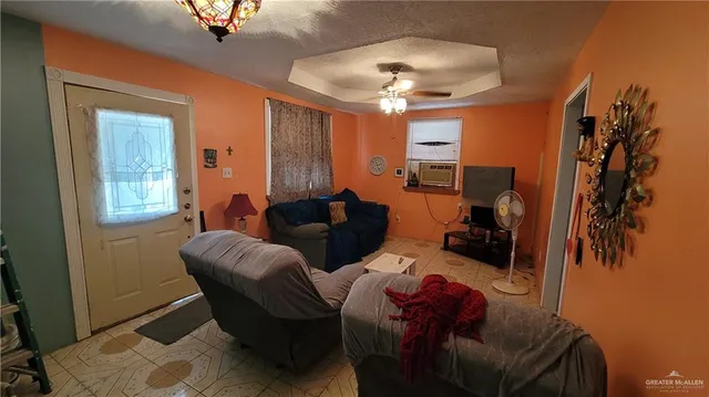 a living room with furniture a chandelier and a window