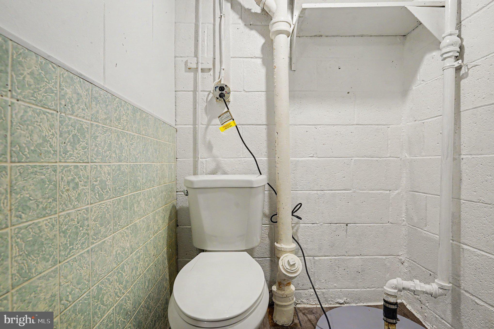 7729 Charlesmont Road Baltimore, MD 21222 - Photo 31 of 43 a white toilet sitting next to a bathroom sink