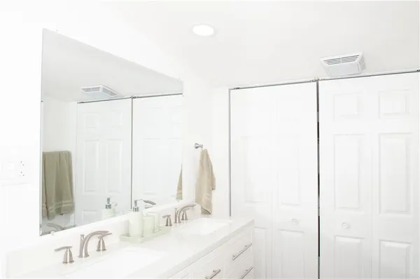a bathroom with a double vanity sink and a mirror