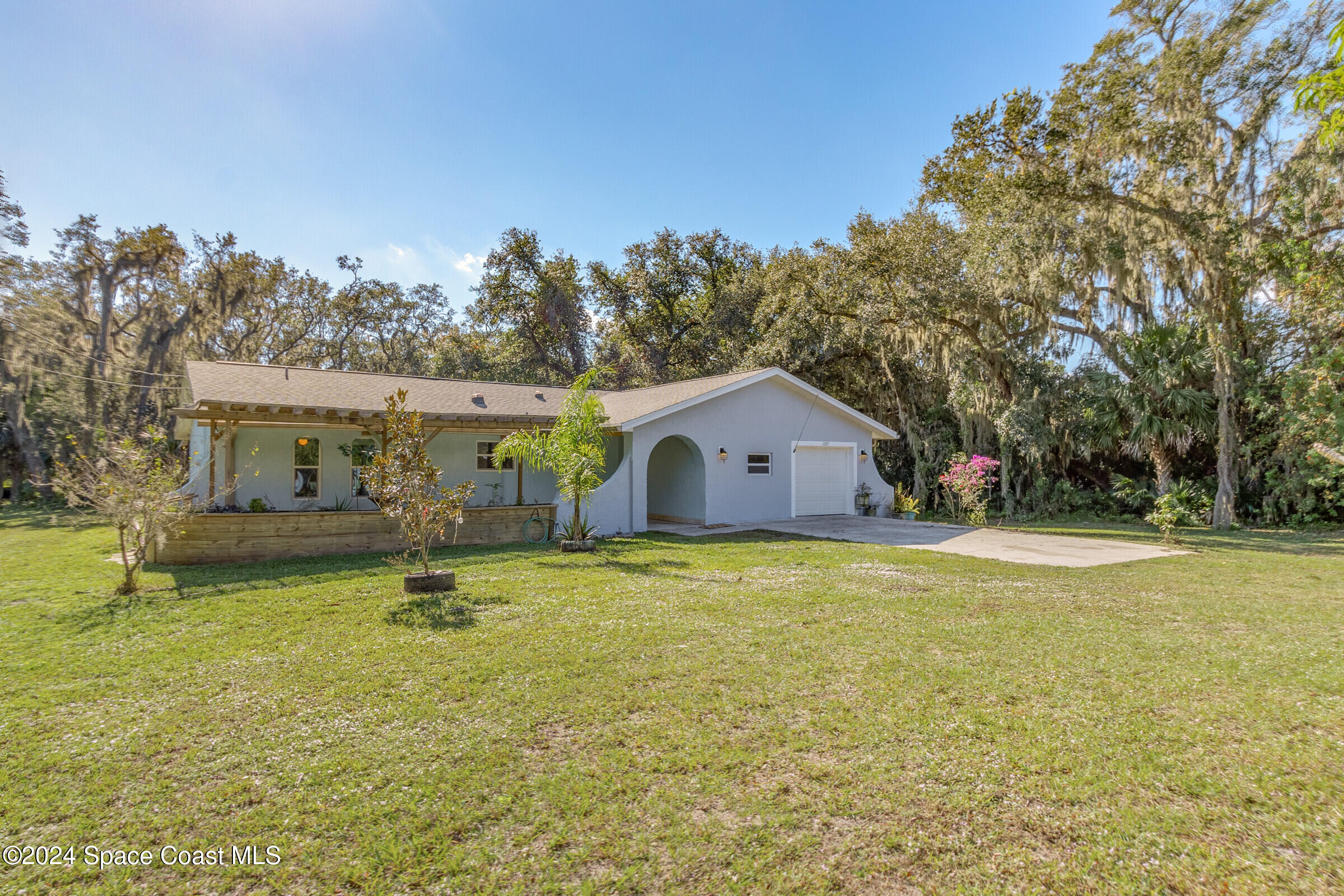 1235 Pine Island Road Merritt Island, FL 32953 - Photo 1 of 45 a view of a house with swimming pool and a yard