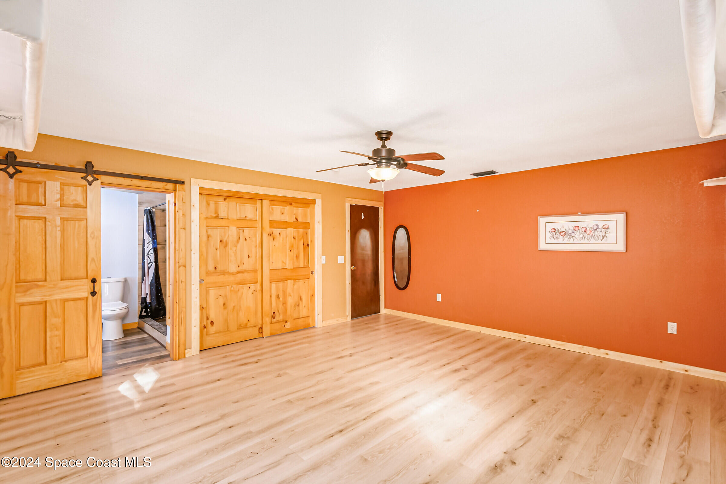 1235 Pine Island Road Merritt Island, FL 32953 - Photo 14 of 45 a view of a livingroom with wooden floor and a ceiling fan